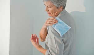 אישה שמה קרח על הכתף שלה