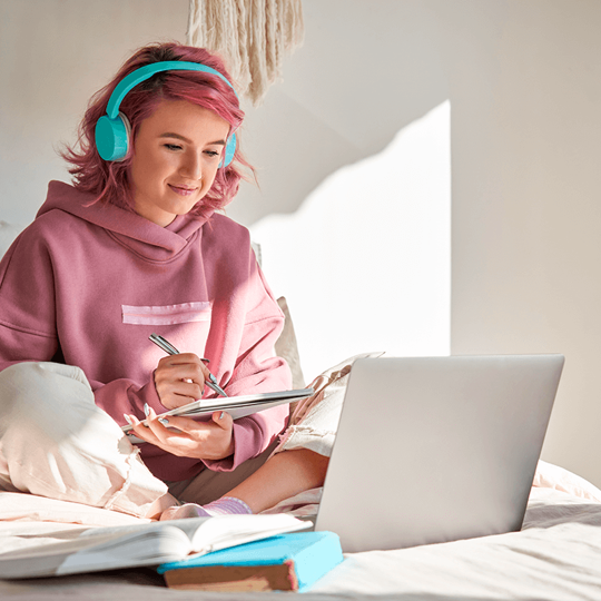 young woman sitting in front of computer with headphone on