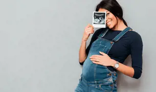 אישה בהריון מחזיקה צילום אולטרה סאונד