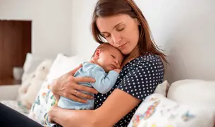 אישה לאחר לידה מחבקת את התינוק שלה