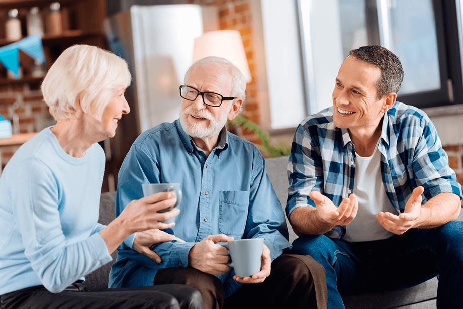 An elderly couple and their son are having a conversation