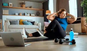 אישה עושה כפיפות בטן ספורט בבית